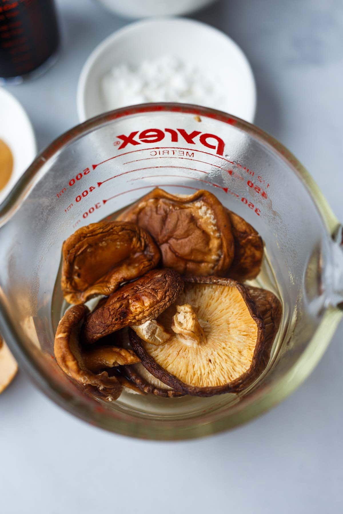 shiitake mushrooms in jar with water, soaking.