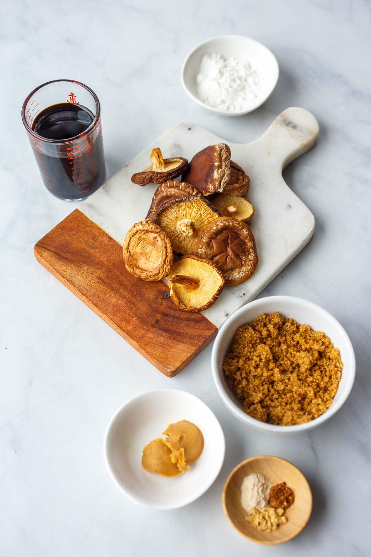 ingredients to make vegan oyster sauce recipe - dried shiitake mushrooms, soy sauce, cornstarch, brown sugar, white miso, spices.