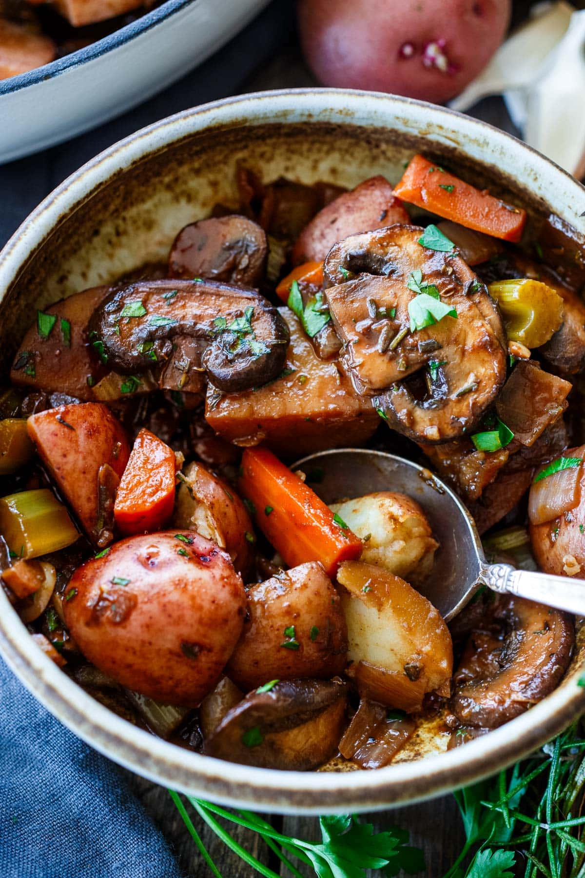 vegetable stew in bowl with minced parsley - potatoes, carrots, mushrooms, celery, onion. 