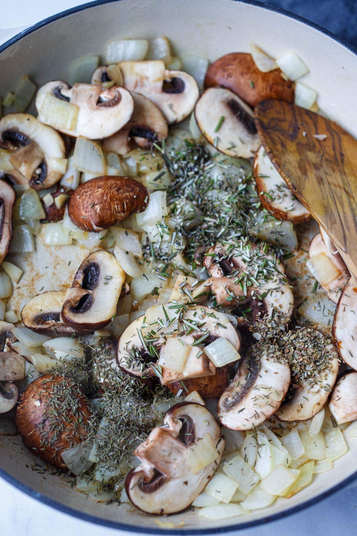 skillet with chopped mushrooms, onions, sautéing with herbs and spices.