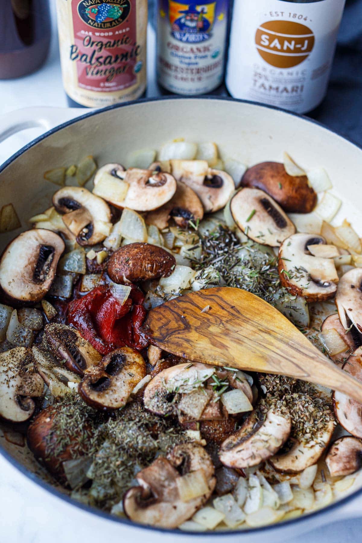 chopped onions, mushrooms sautéing in pan with tomato paste, herbs, spices.