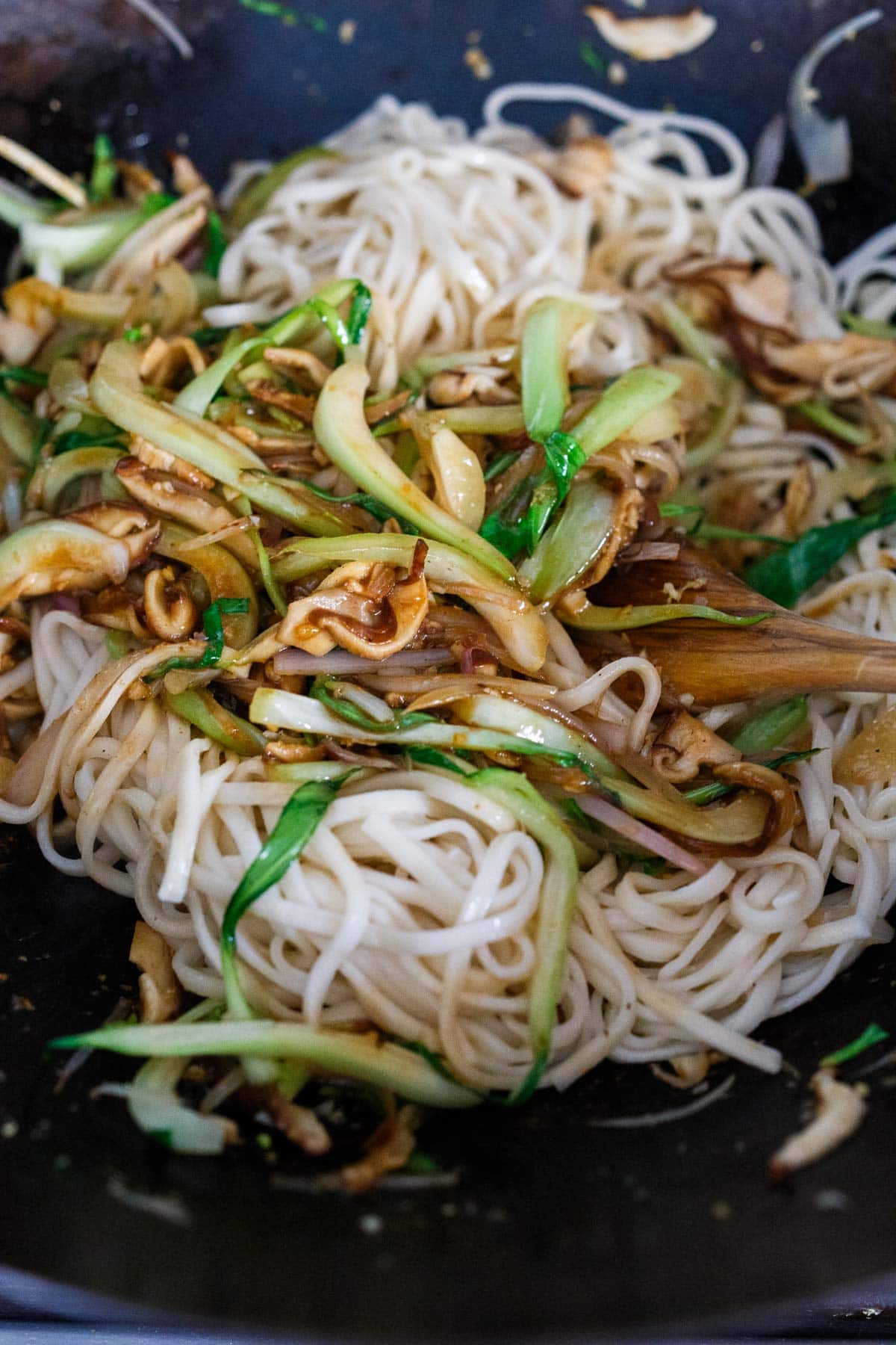 longevity noodles added to wok with sautéed vegetables.
