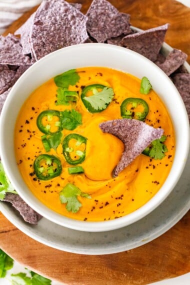 This creamy Vegan Queso recipe is so delicious! A highly adaptable recipe packed with wholesome veggies and perfect for as a dip, or over nachos, tamales, burrito bowls, and tacos.