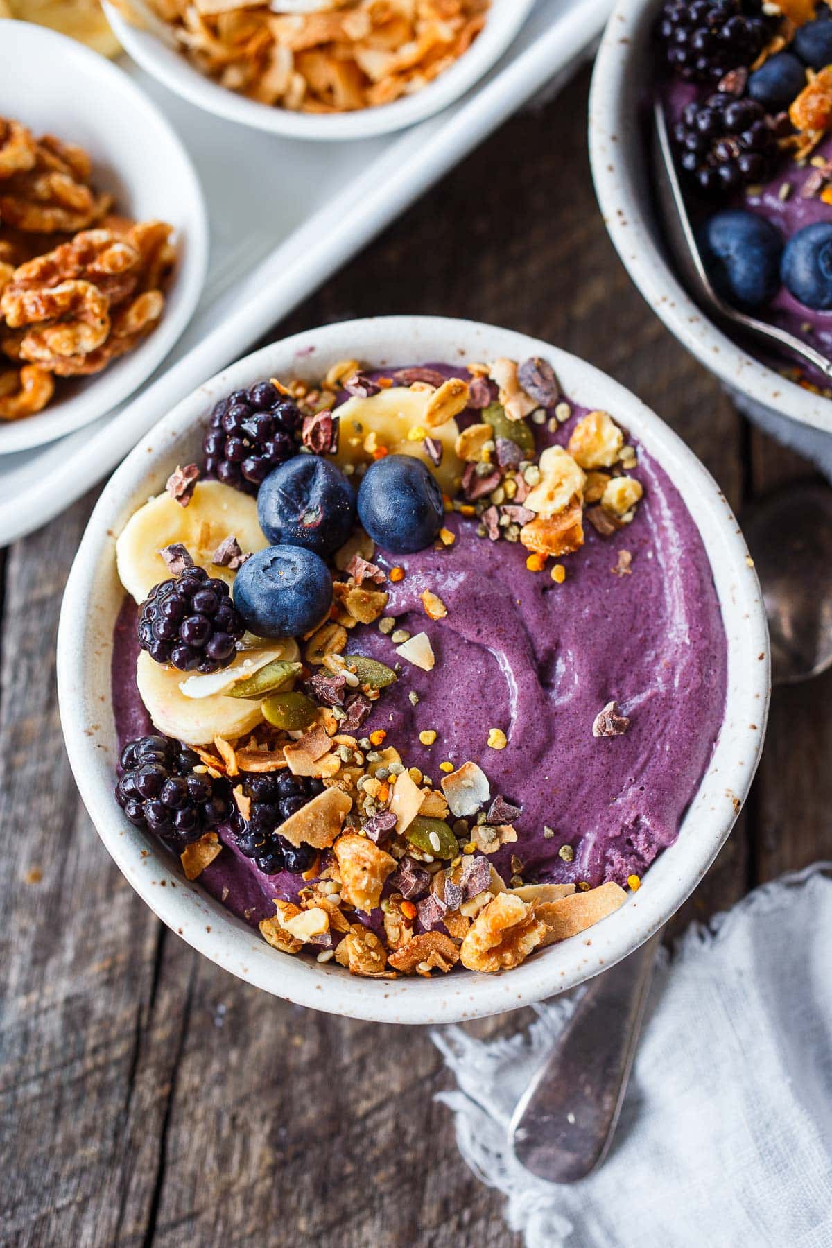 acai bowl topped with blueberries, blackberries, sliced bananas, granola, toasted coconut, and bee pollen.