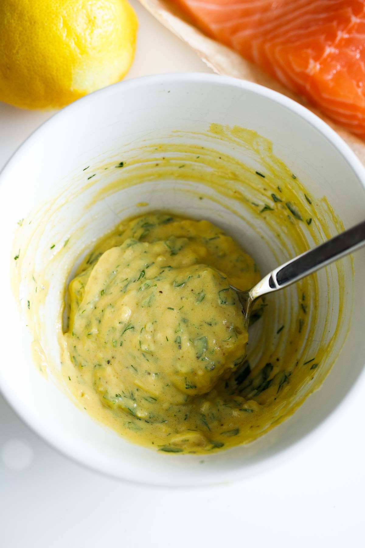 mixing dijon mixture in bowl with spoon.