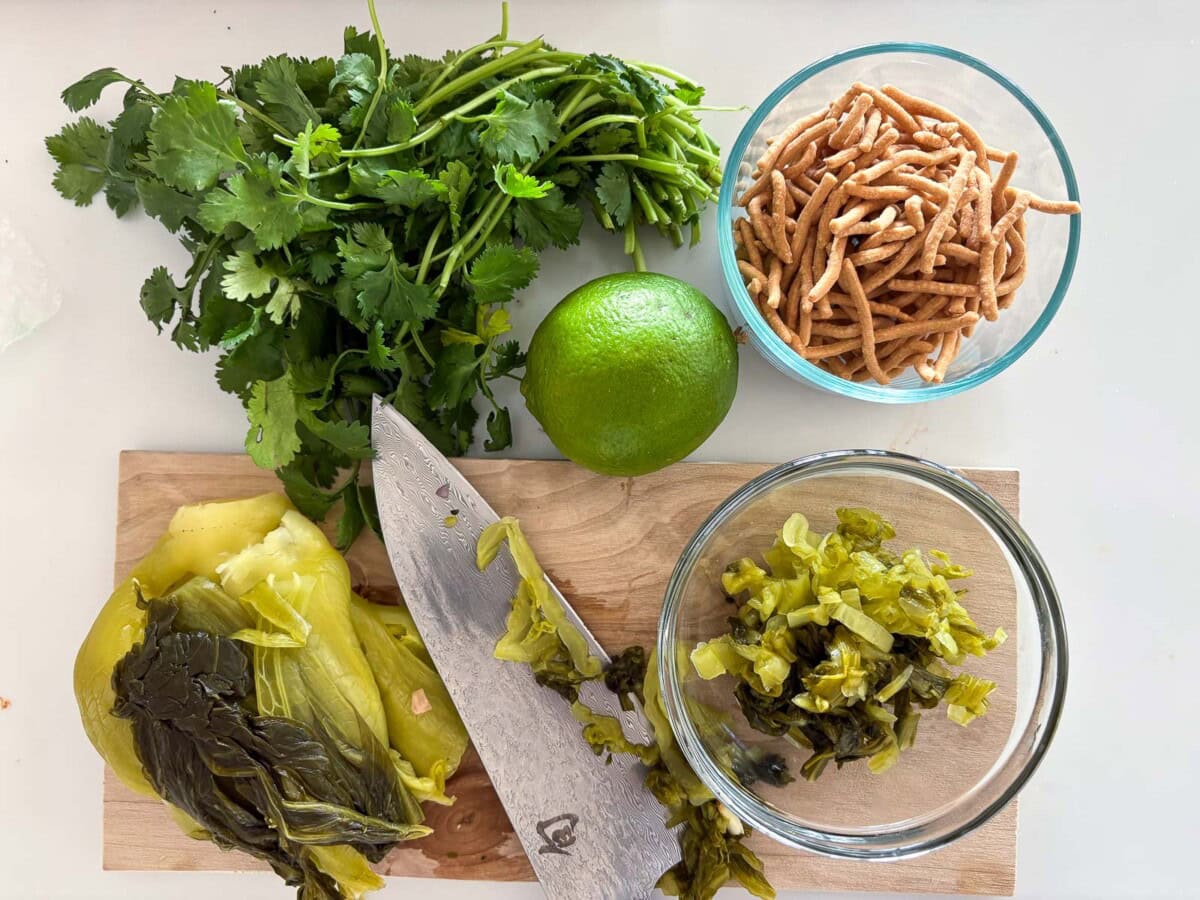 Khao soi toppings: mustard greens, crunchy noodles, lime and herbs.