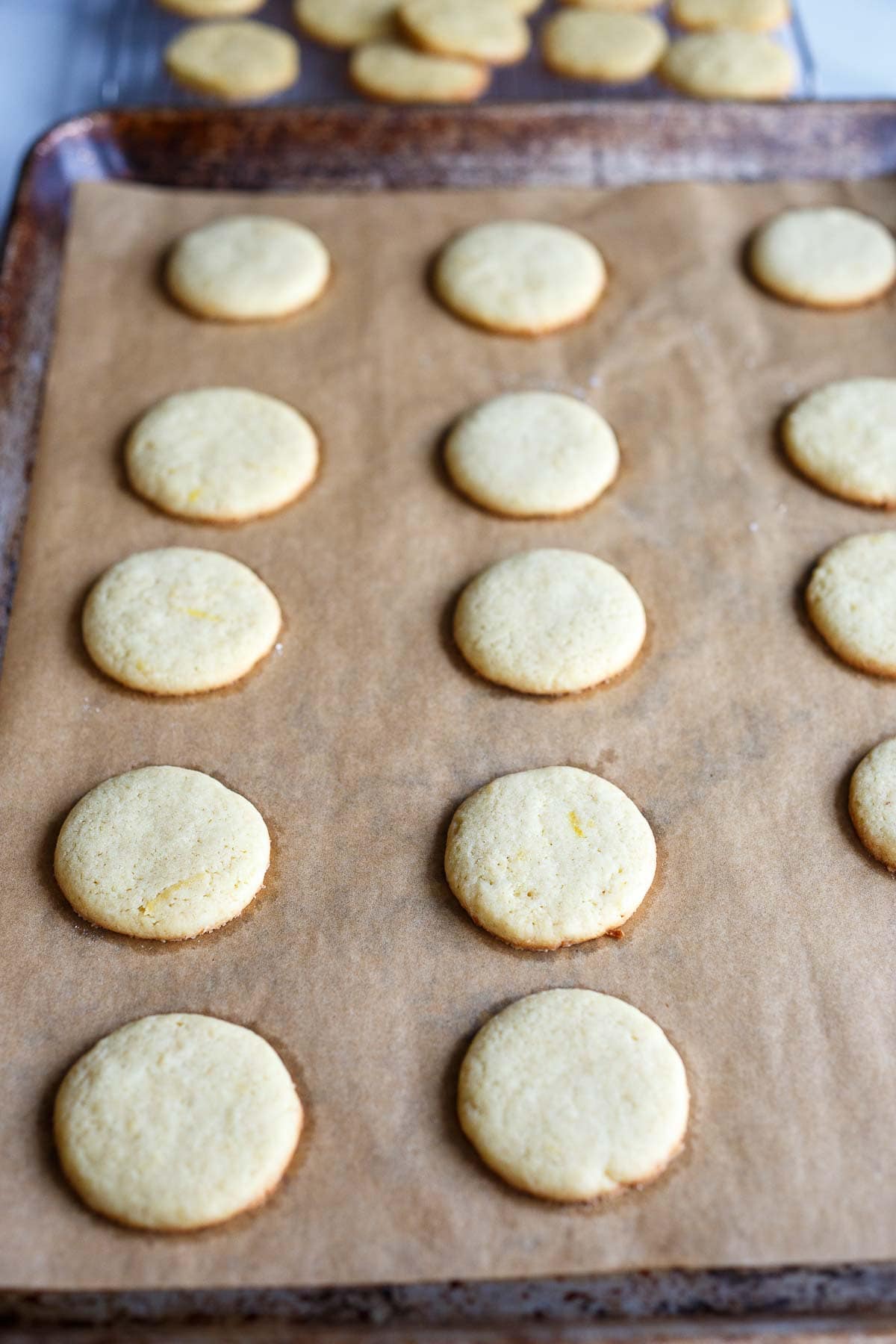 baked lemon cookies on parchment-lined baking sheet.