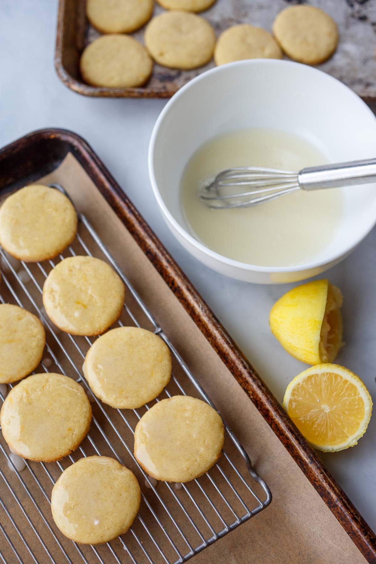 lemon cookies on cooling rack with lemon glaze on top.