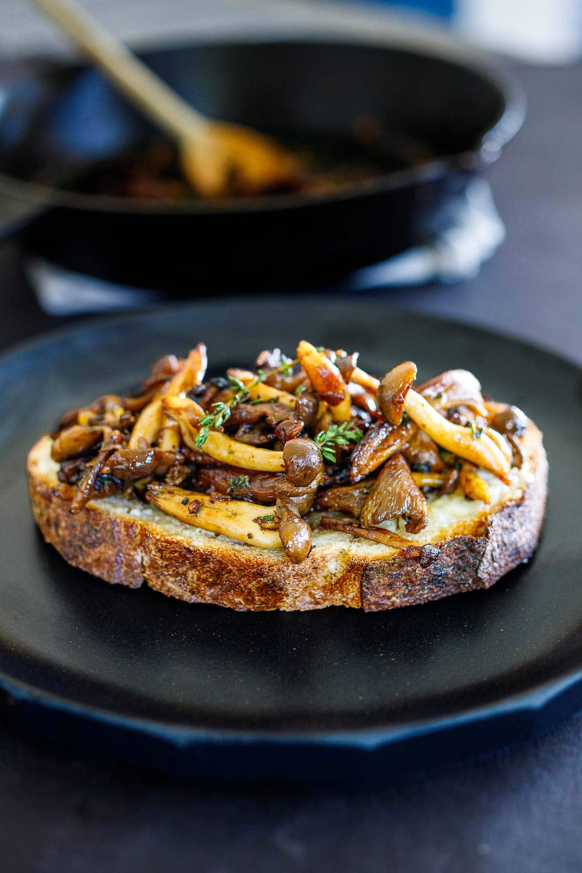 mushroom toast with mixed sautéed mushrooms, garnished with fresh thyme.
