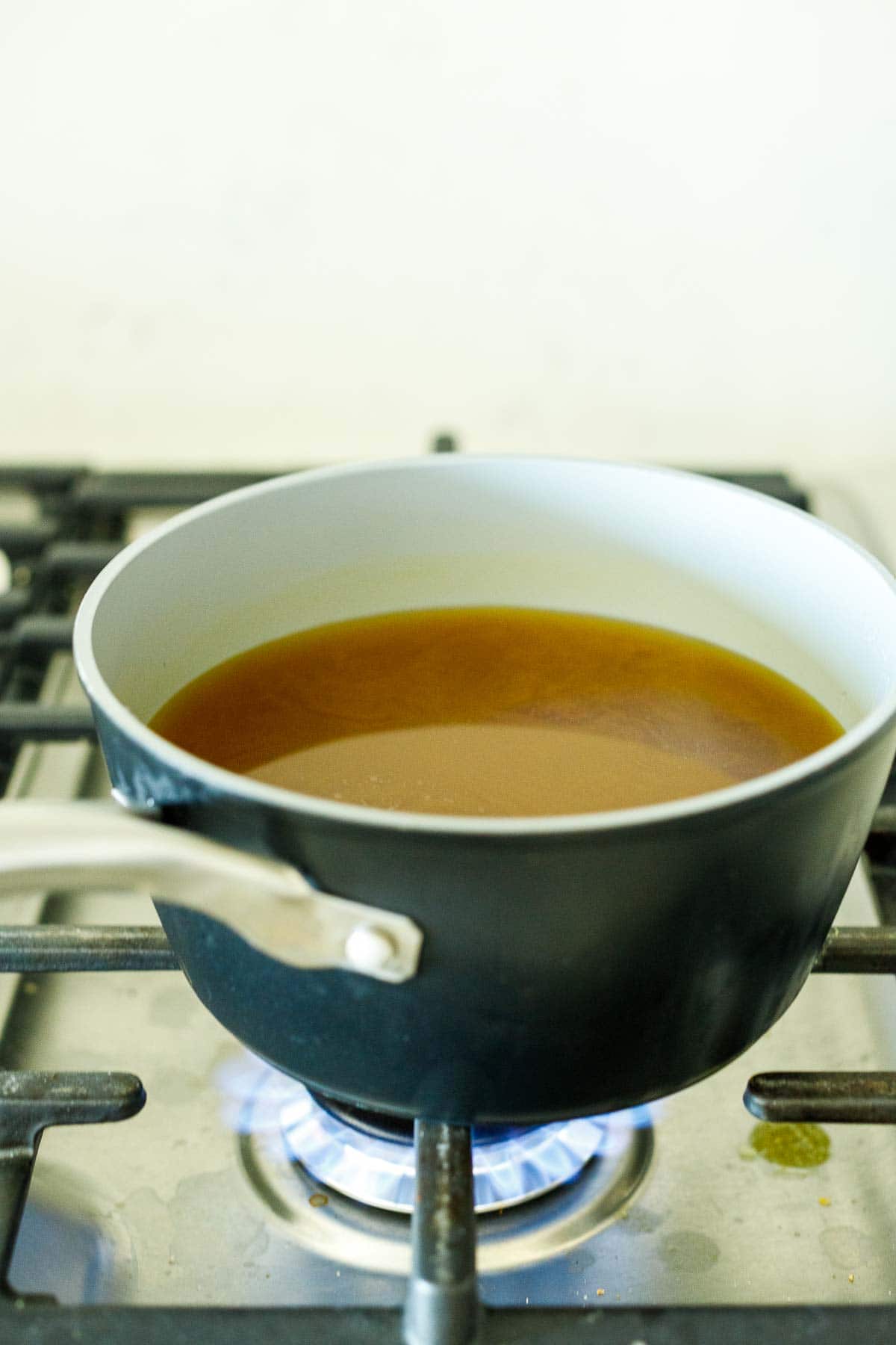 vegetable broth warming in saucepan on stovetop.