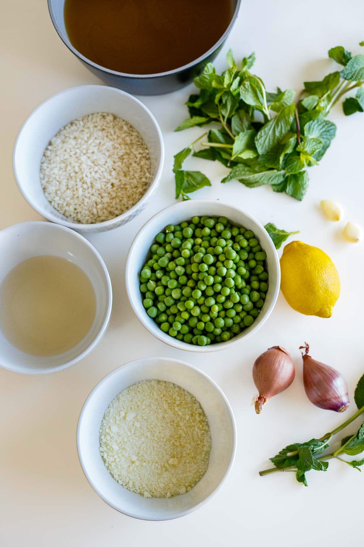 spring pea risotto ingredients- broth, mint, rice, peas, lemon, garlic, shallot, oil, pecorino. 