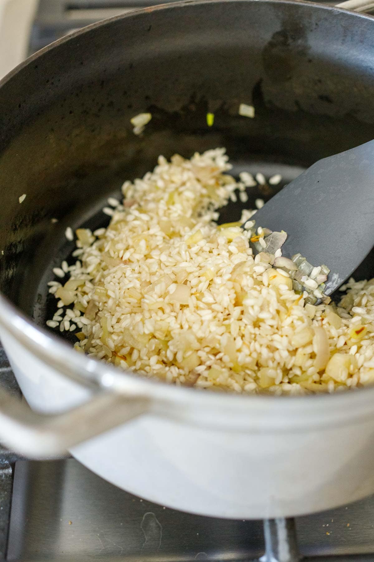 arborio rice in dutch oven with onions and garlic. 