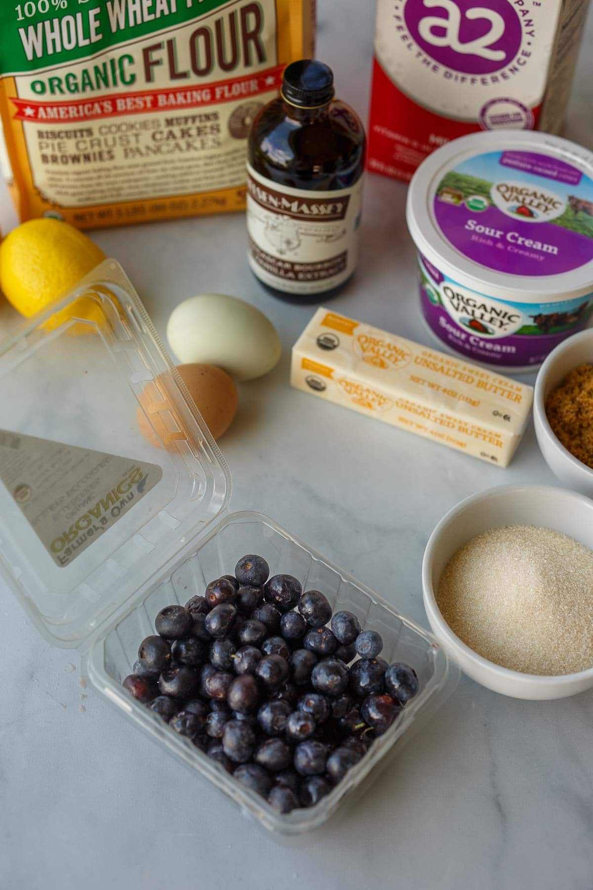 blueberry coffee cake ingredients- fresh blueberries, sugar, butter, eggs, sour cream, vanilla, lemon, flour, milk.