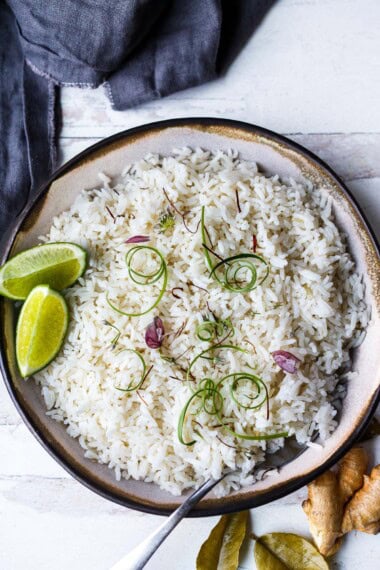 Fluffy, light and delicious, this easy Coconut Rice recipe is made on the stovetop and enhanced with coconut milk, lemongrass, and ginger. A vegan, gluten-free side dish in 30 minutes.