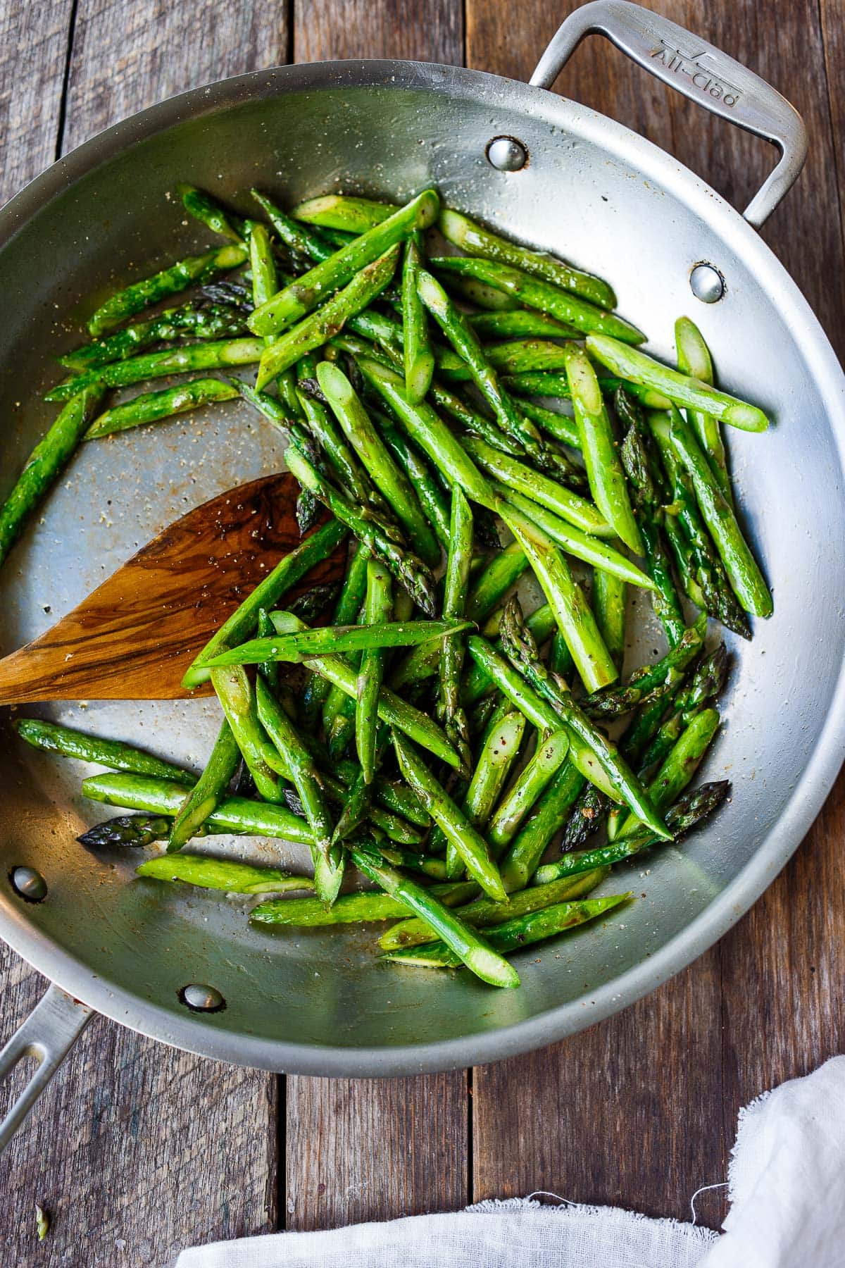 skillet with sauteed asparagus seasoned with salt and pepper.