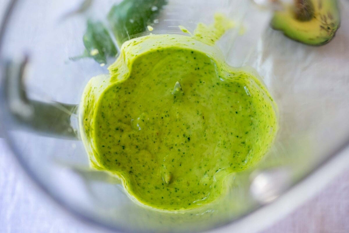 creamy avocado sauce blended in glass blender. 