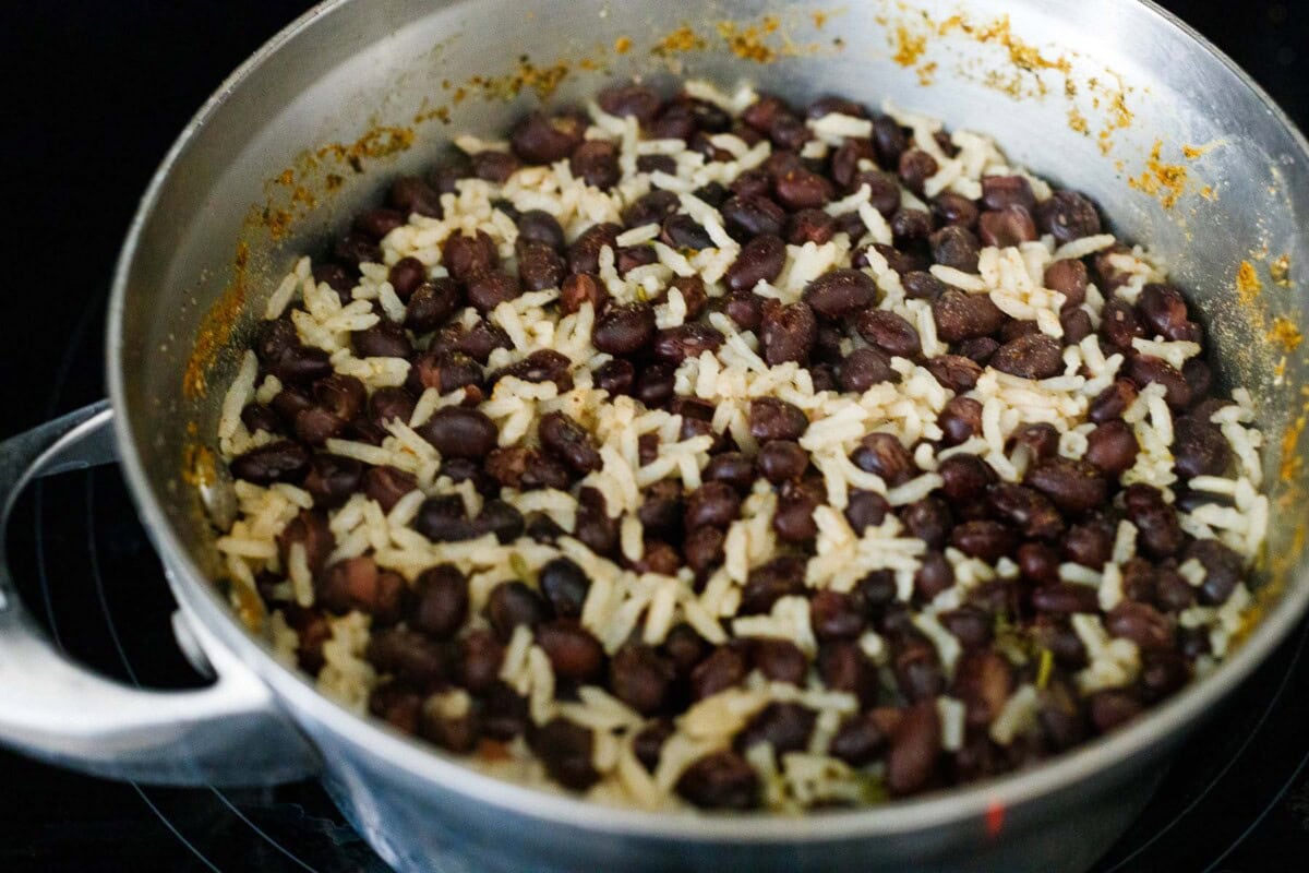 cooked rice and beans in pot with spices.