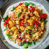 Air fryer Crispy Cauliflower over creamy tahini yogurt sauce with pickled red onions and herbs.