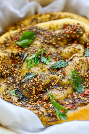 Tender Lebanese flatbread called manoushe is slathered with a mixture of zaatar spice and olive oil, a delicious appetizer or breakfast on the go. Vegan & gluten-free adaptable.