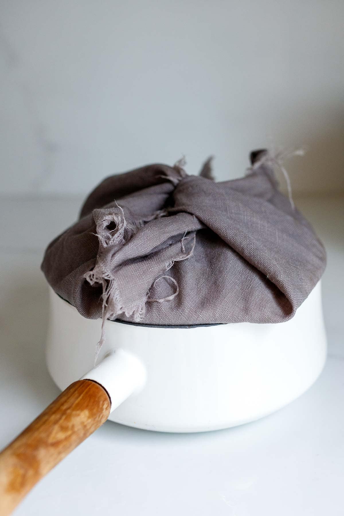 kitchen towel wrapped around lid of pot.