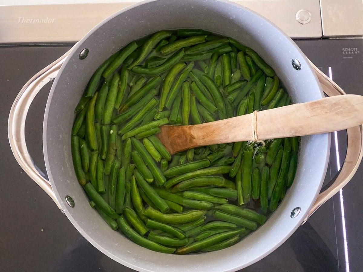 large pot with trimmed fresh green beans in water. 