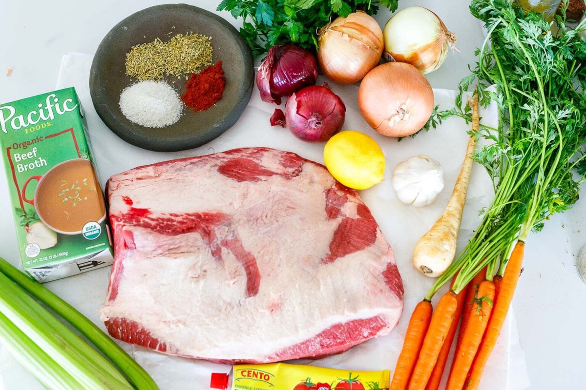 ingredients for oven brisket- brisket, carrots, parsnip, garlic, lemon, onions, parsley, spices, beef broth, celery, tomato paste.