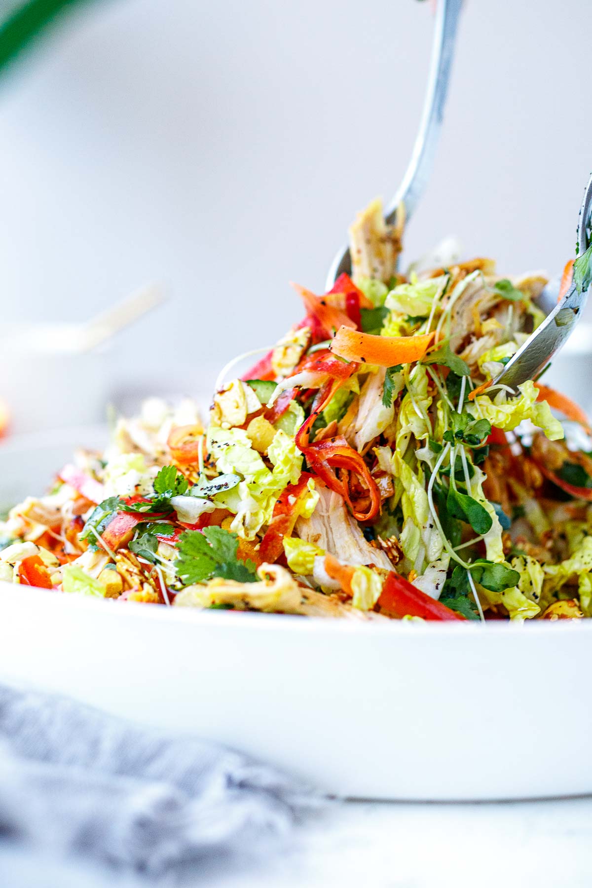 salad serving utensils mixing together the chinese chicken salad.