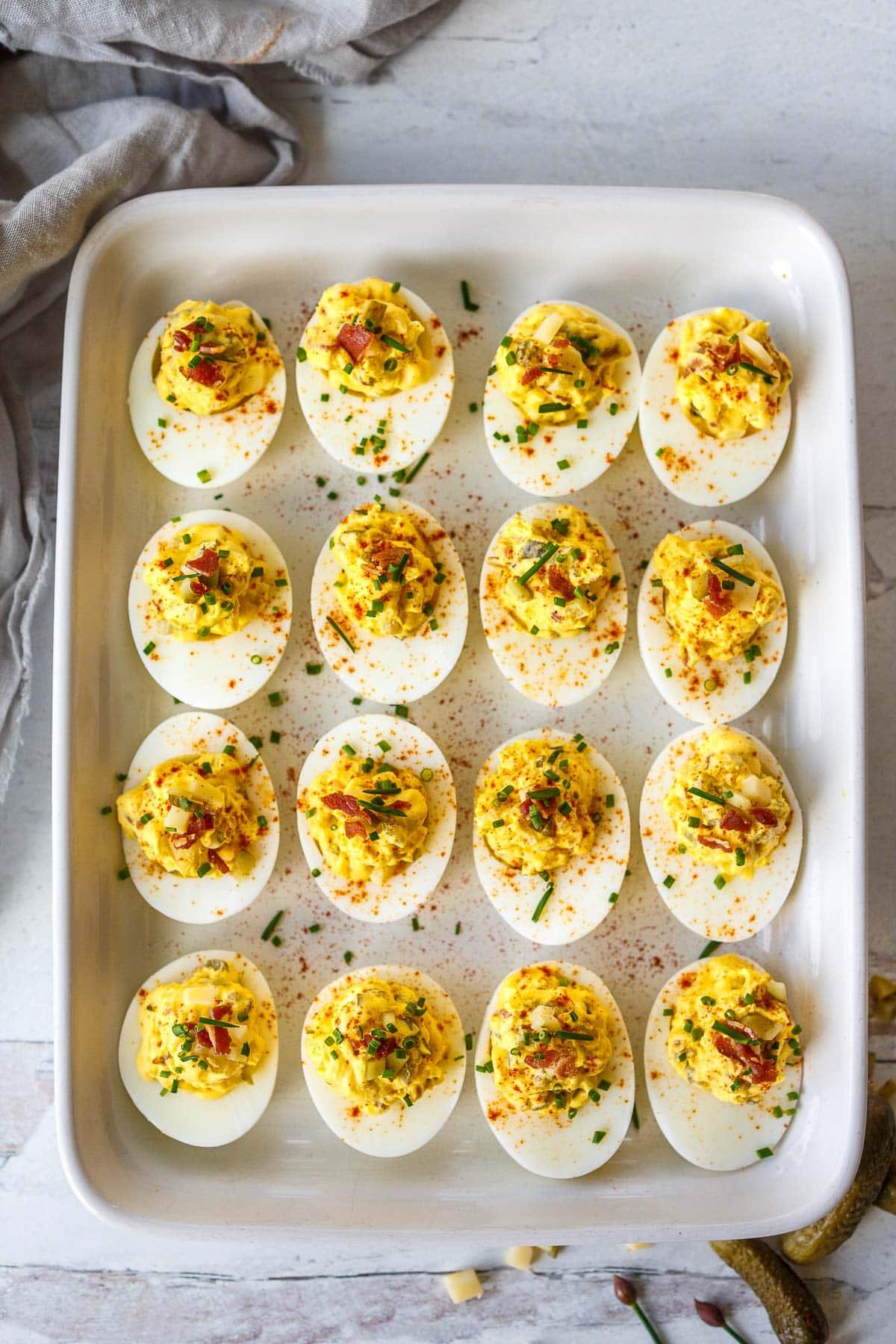 These deviled eggs (also known as Oeufs Mimosa) have the best texture and flavor! They are creamy and delicious, studded with crispy bacon (or vegan bacon), aged cheddar cheese, diced pickles, and sweet onions. The perfect low-carb appetizer, perfect for gatherings!