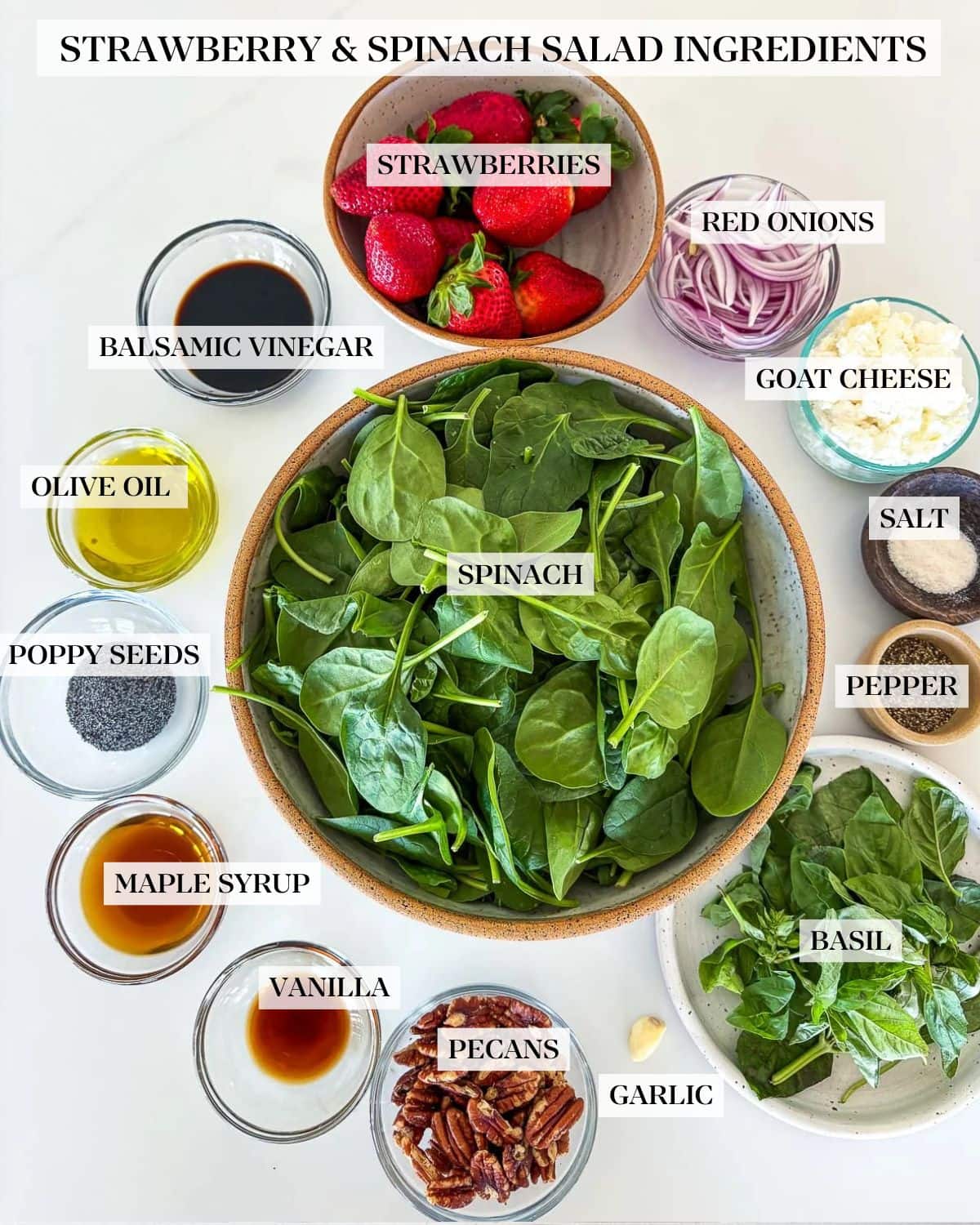strawberry spinach salad ingredients on a white counter.