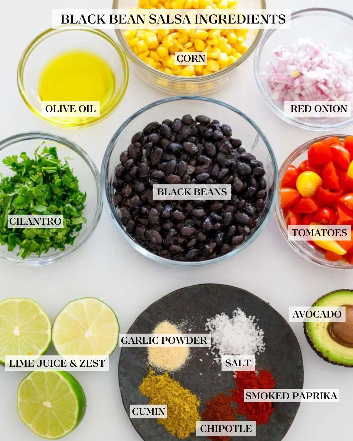 ingredients for black bean salsa arranged neatly in bowls - corn, onions, cherry tomatoes, black beans, olive oil, cilantro, avocado, limes, and spices. 