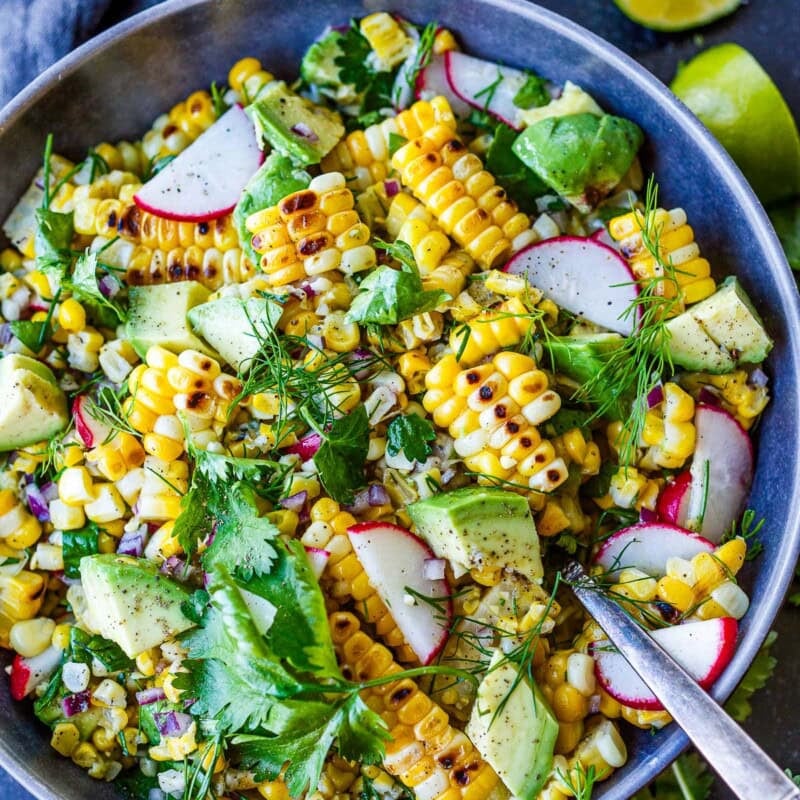 This grilled corn salad recipe sings of summer! A fresh, healthy side dish that highlights fresh summer corn, creamy avocado, radishes, red onion, and fresh herbs, tossed in a simple, tangy lime dressing. Vegan and gluten-free.