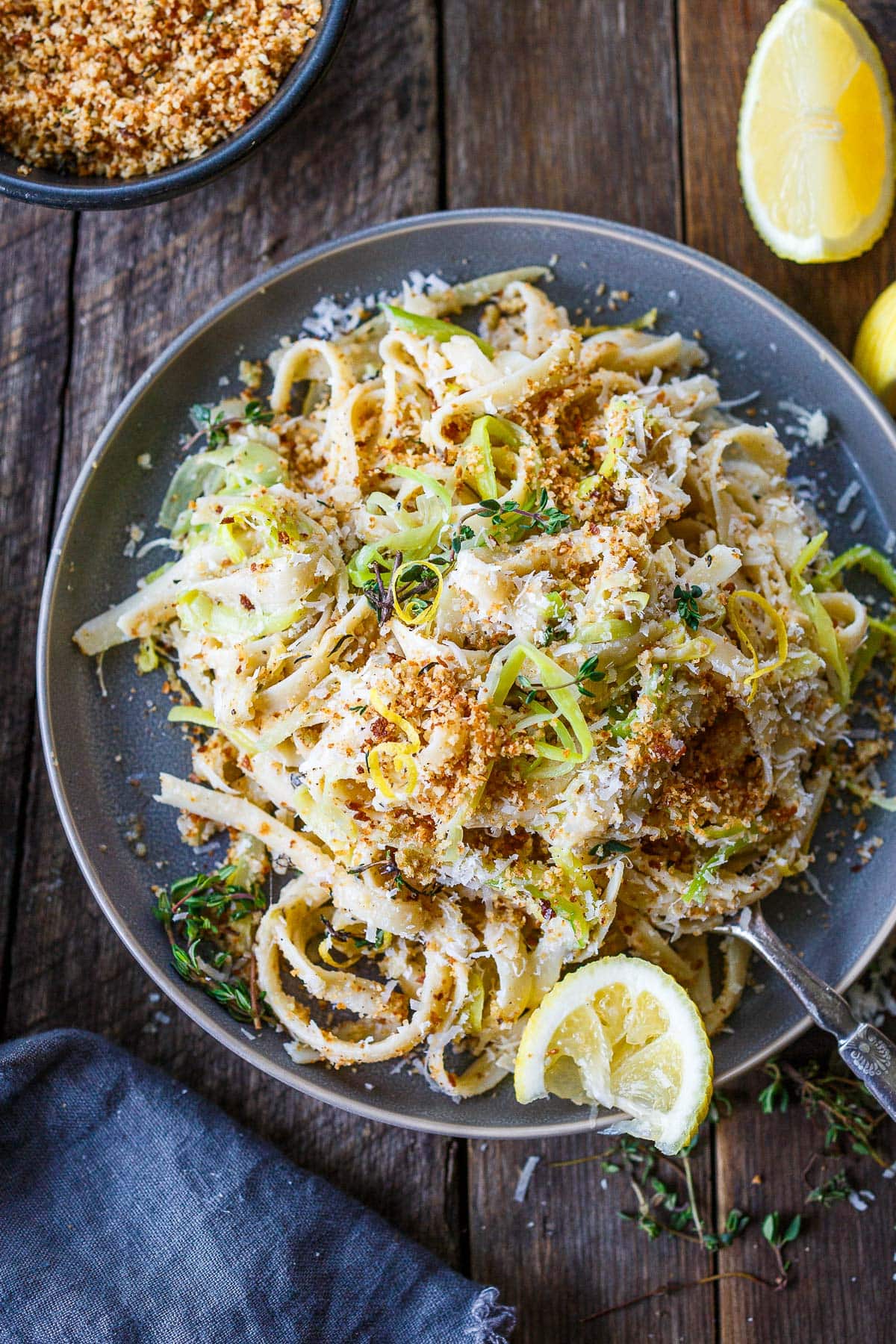 plate of caramelized leek pasta topped with pangritata, pecorino, thyme, and lemon zest.