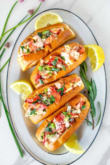 This light and lemony Maine-style lobster roll recipe is the best! Made with tender lobster meat, lemon zest, tarragon, chives, celery, & mayo. 