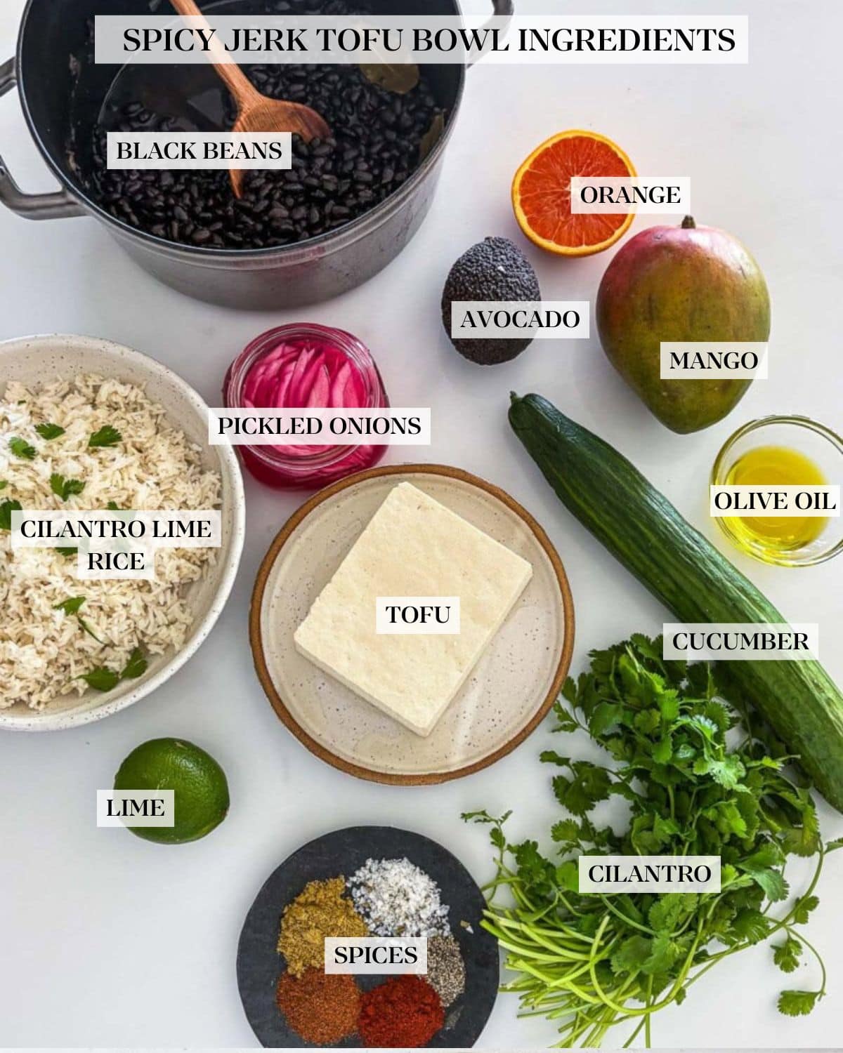 ingredients laid out for tofu bowl - pot of cooked black beans, orange, mango, avocado, oil, cucumber, cilantro, tofu, spices, lime, pickled onions, and rice.