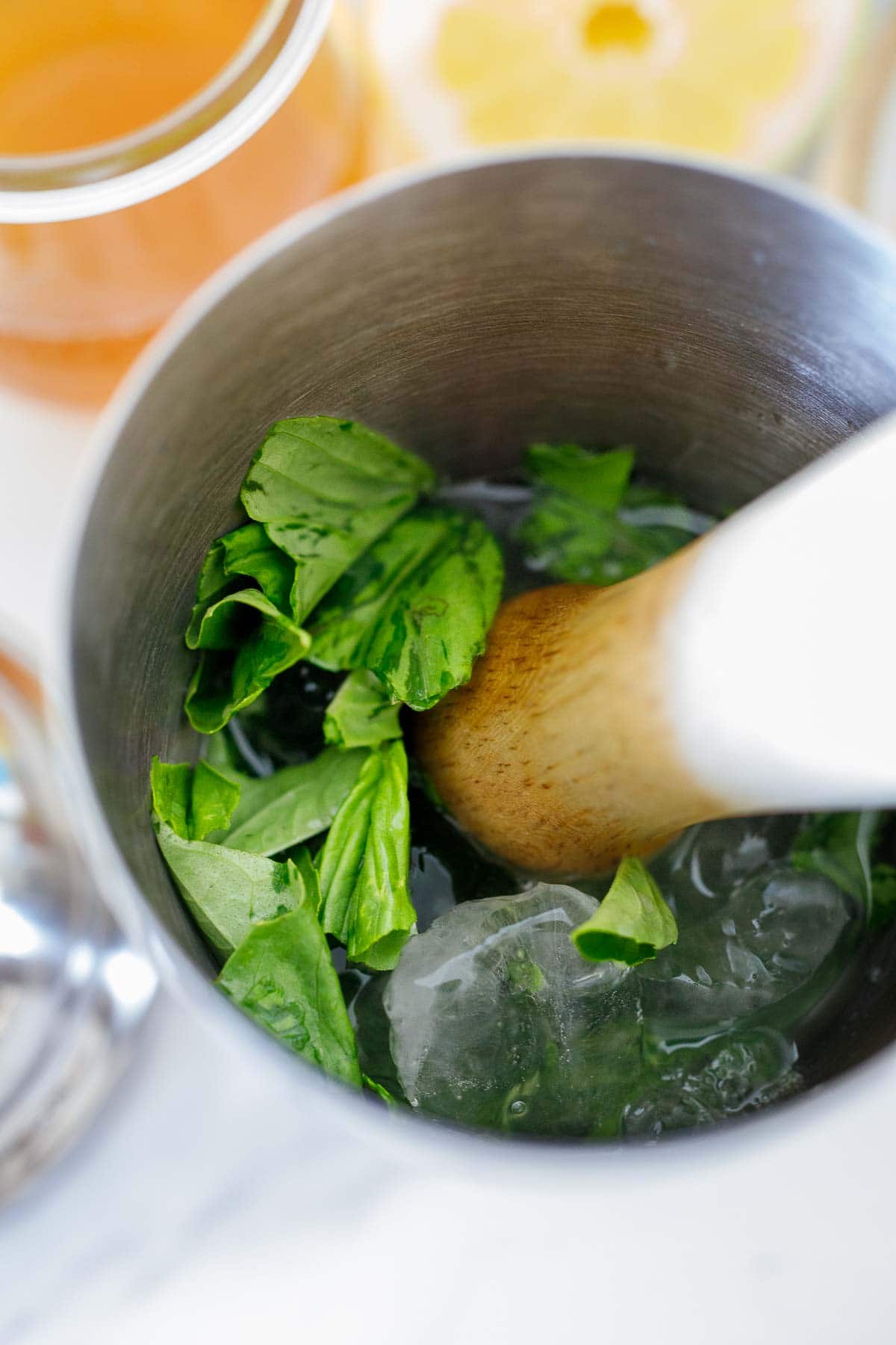 muddling the basil, gin, and ice in a shaker.