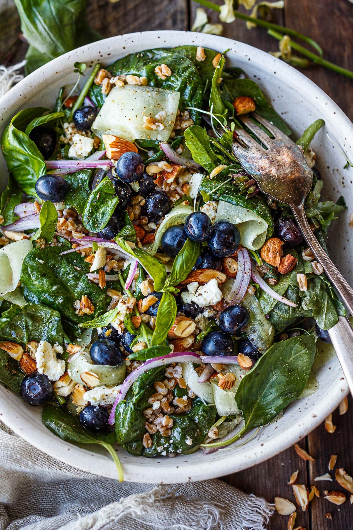 blueberry salad with spinach, red onion, almonds, shaved cucumber, feta, and farro.