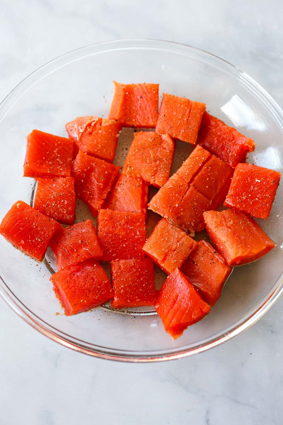 Salmon cubes in a glass bowl.