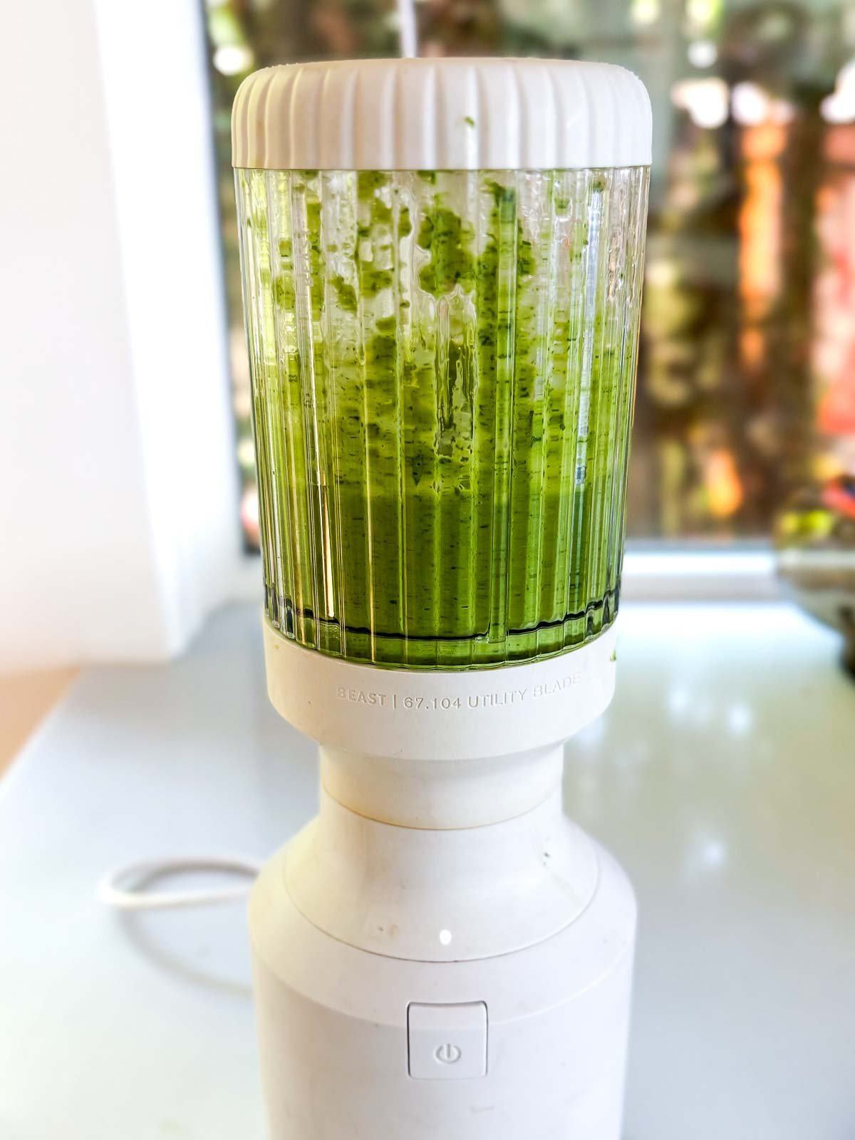 white and glass Beast blender with basil vinaigrette blended. 