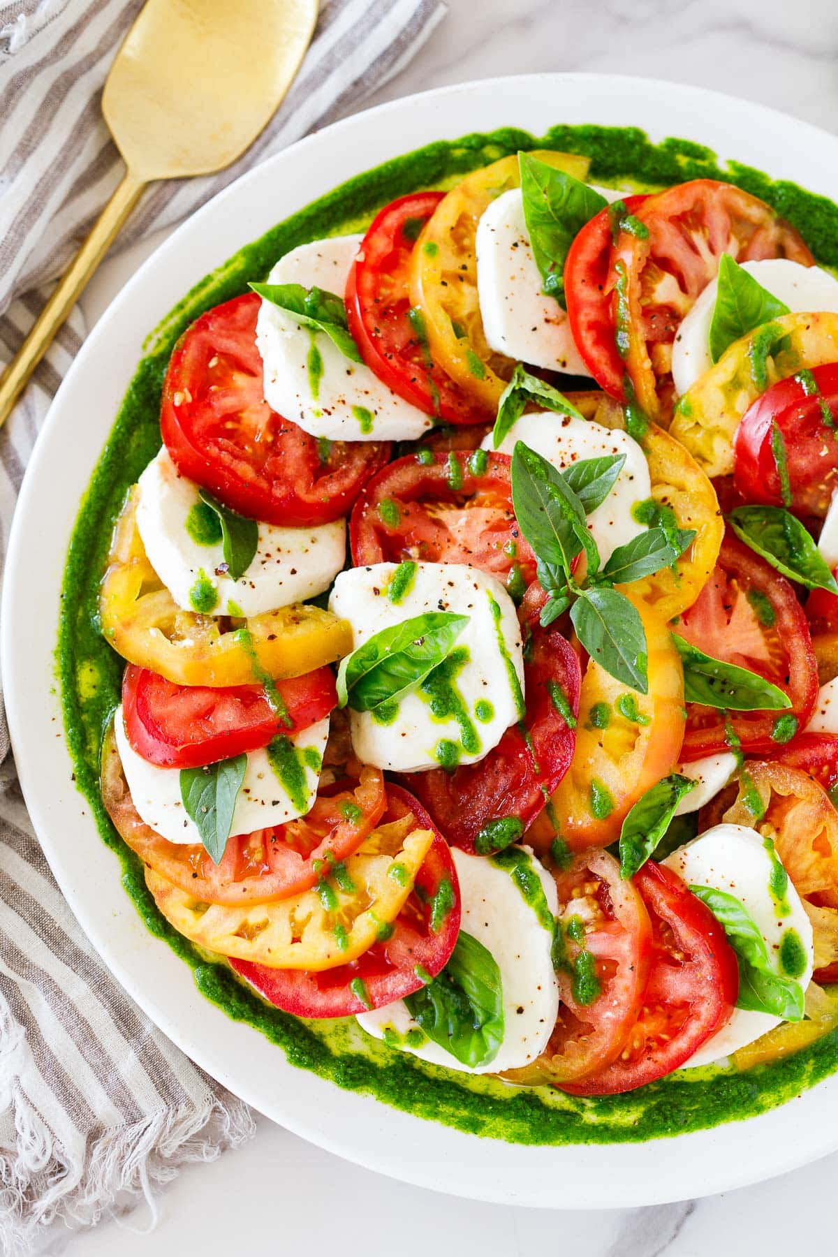 You'll love this Caprese Salad! Made with juicy summer tomatoes, fresh mozzarella cheese, basil leaves, and a balsamic glaze, we give it a little "upgrade" with Basil Oil.