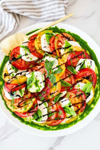 You'll love this Caprese Salad! Made with juicy summer tomatoes, fresh mozzarella cheese, basil leaves, and a balsamic glaze, we give it a little "upgrade" with Basil Oil.