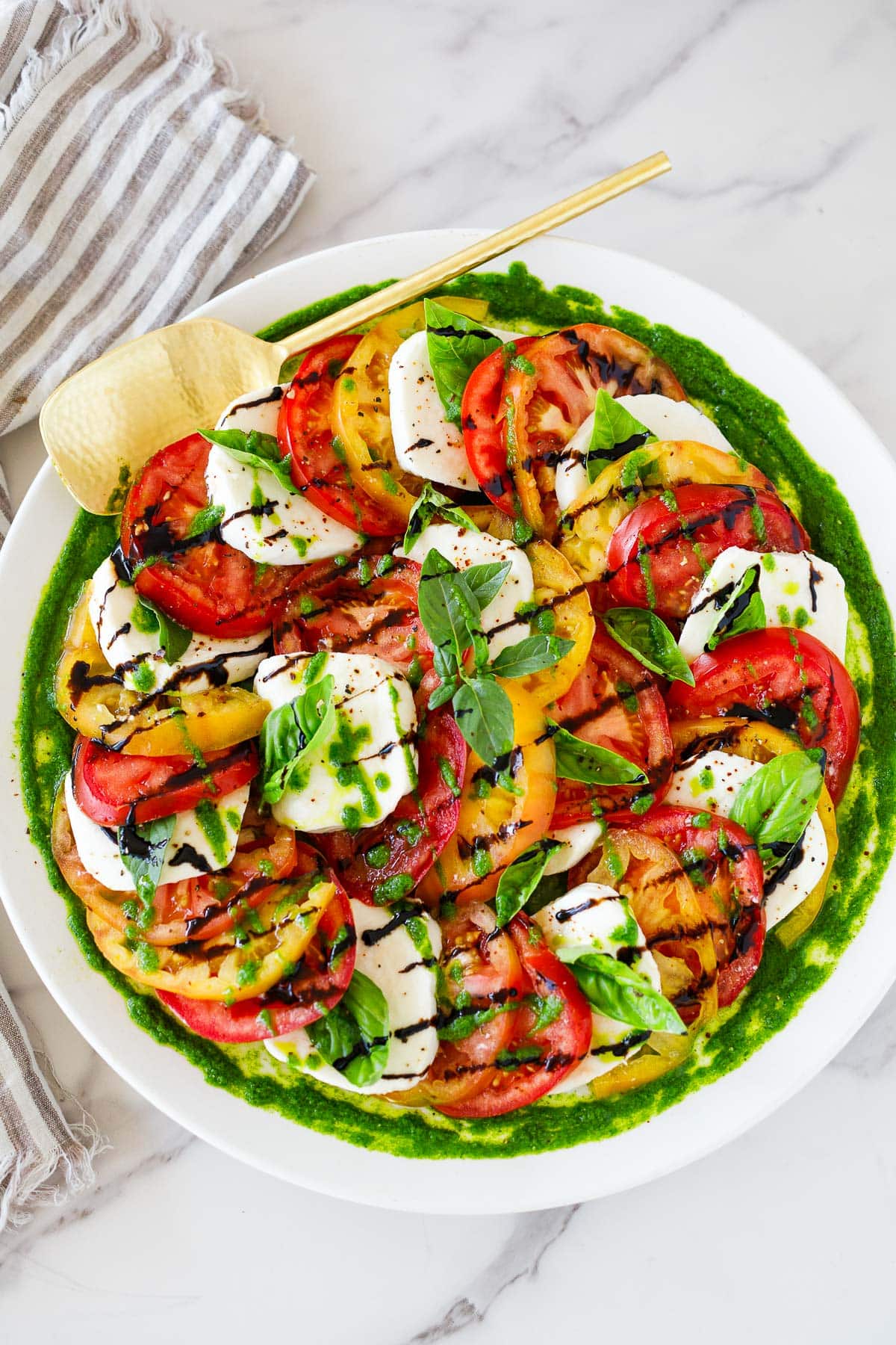 You'll love this Caprese Salad! Made with juicy summer tomatoes, fresh mozzarella cheese, basil leaves, and a balsamic glaze, we give it a little "upgrade" with Basil Oil.