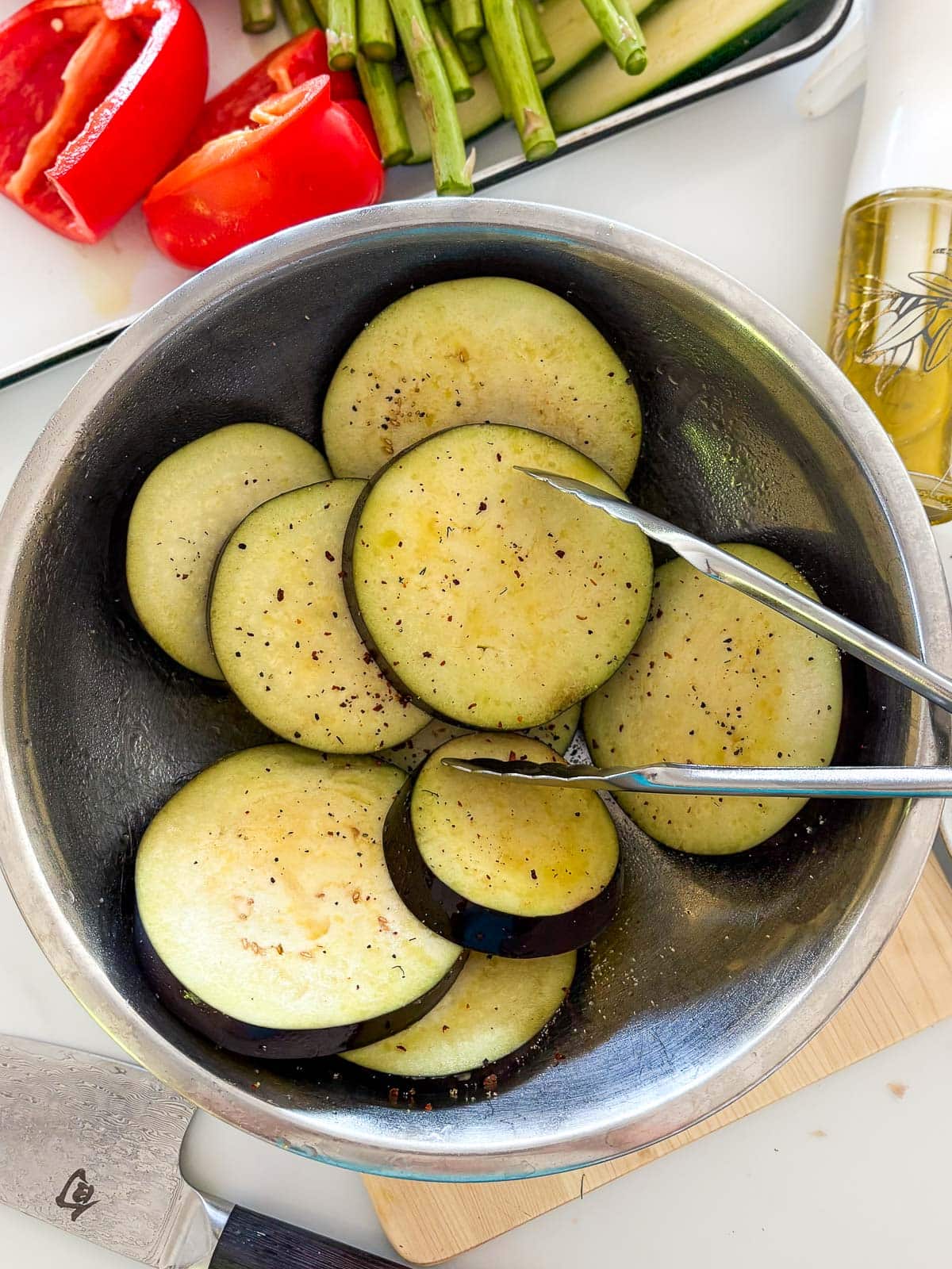 Seasoning eggplant slices.