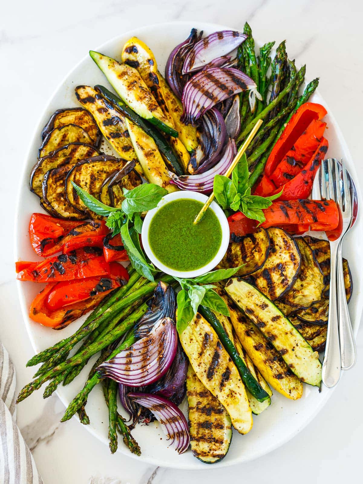 perfectly grilled vegetables on a large platter with basil vinaigrette.