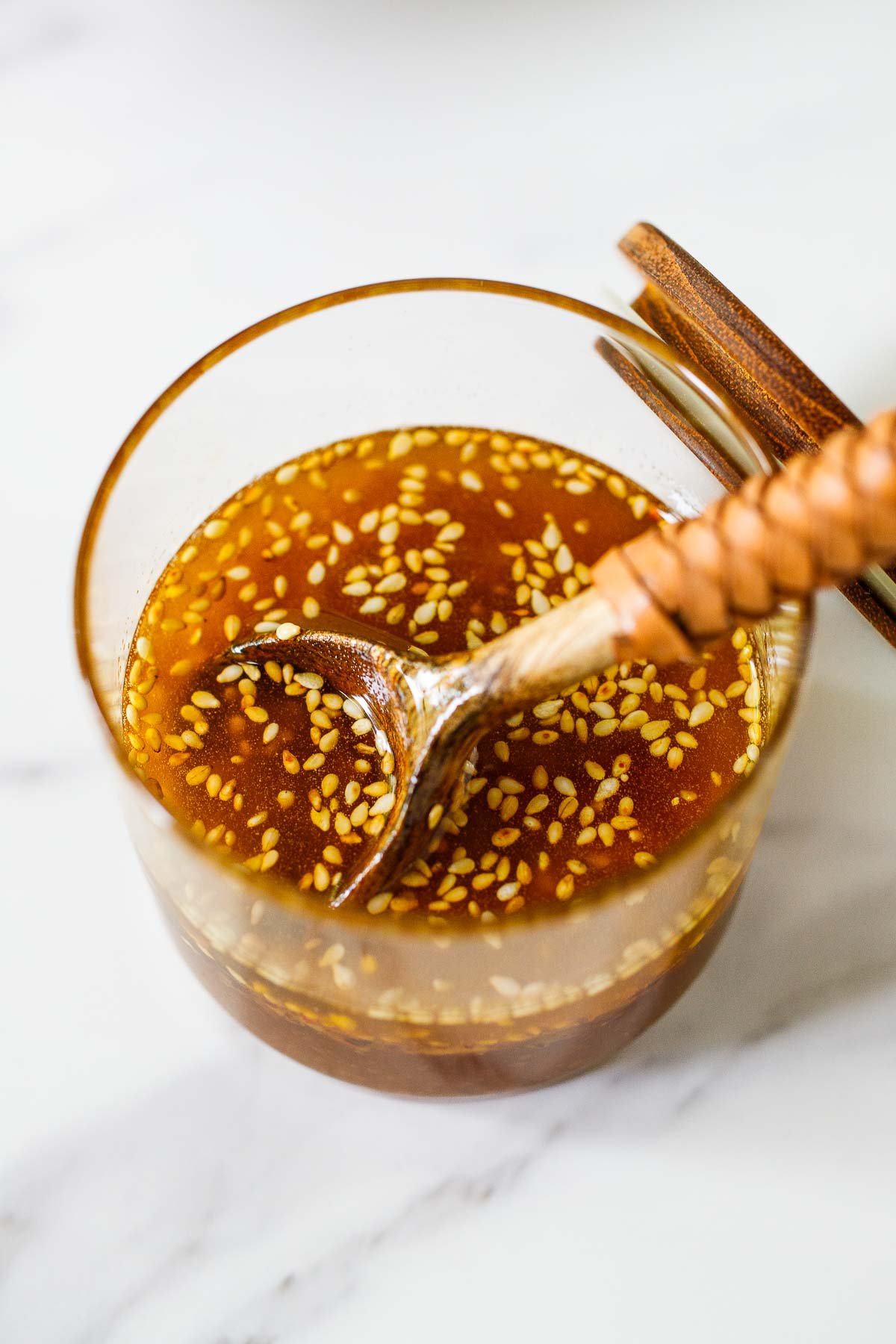 jar of healthy sesame ginger dressing with a spoon.