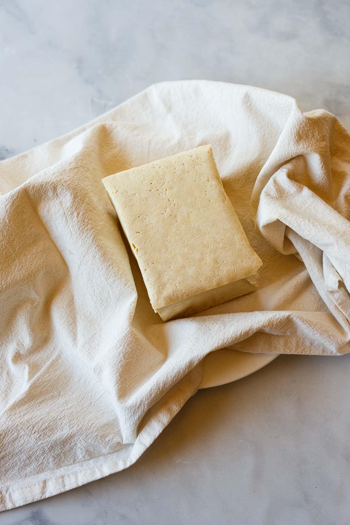 block of tofu on clean kitchen towel. 