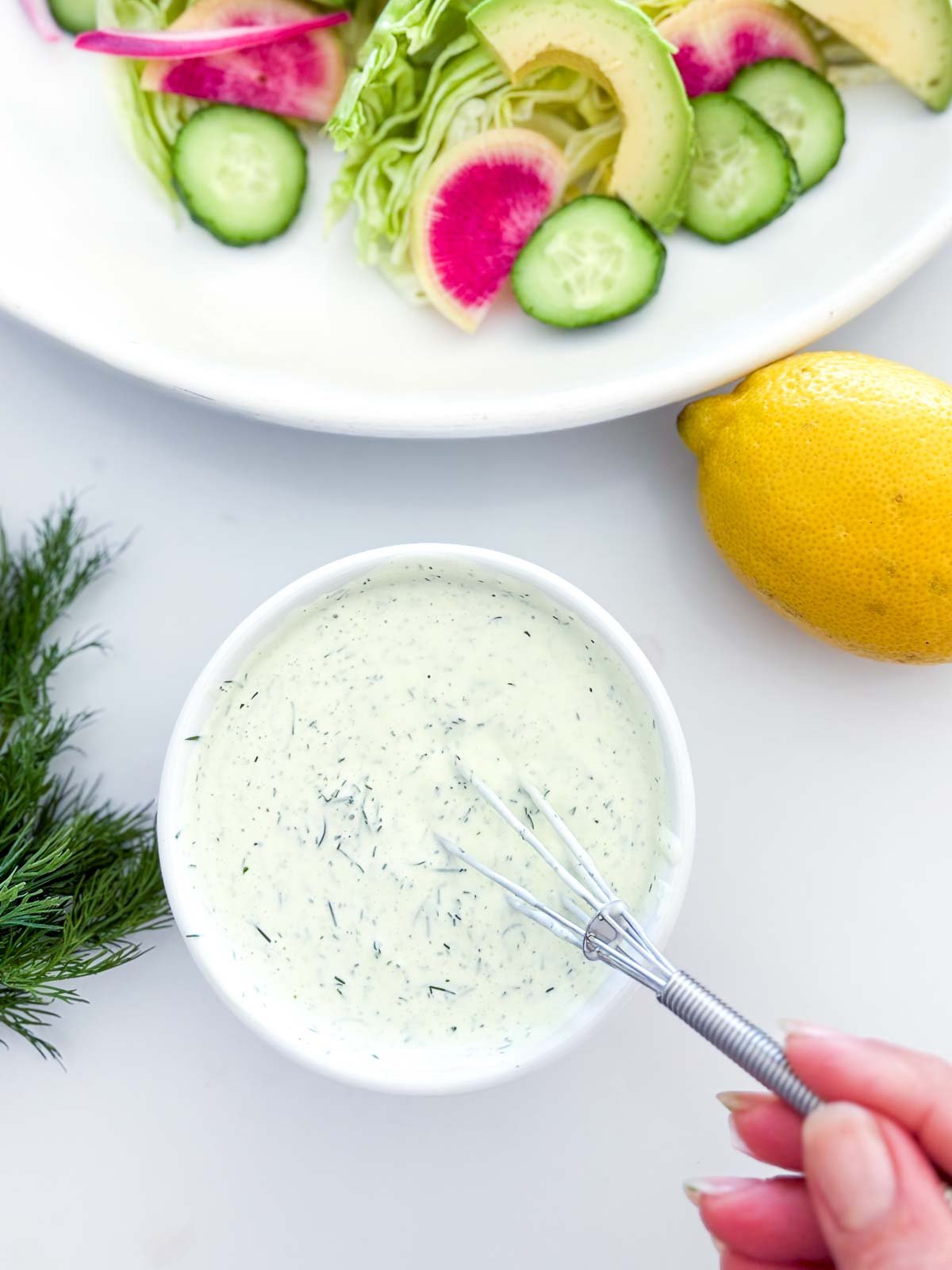 whisking the dill ranch dressing in a small bowl.