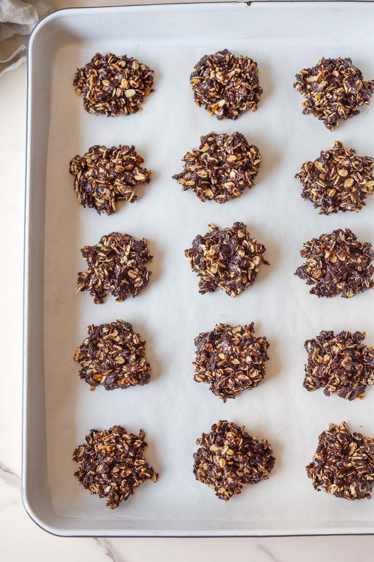 baking sheet with parchment paper and no bake cookies arranged neatly.