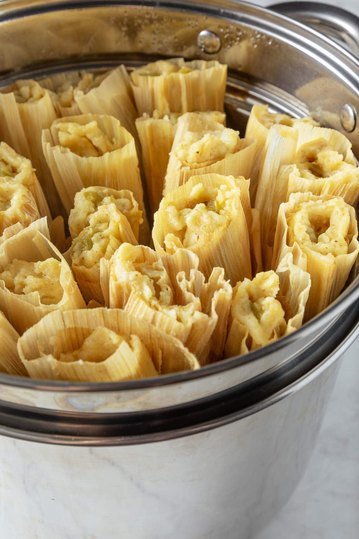 assembled tamales upright in steamer basket. 
