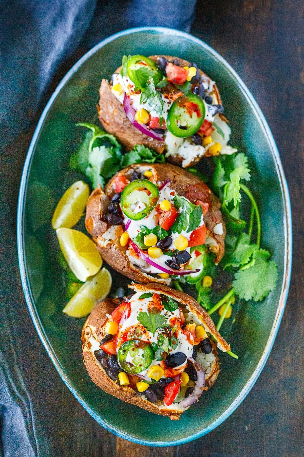 Mexican stuffed baked potatoes on a green platter.
