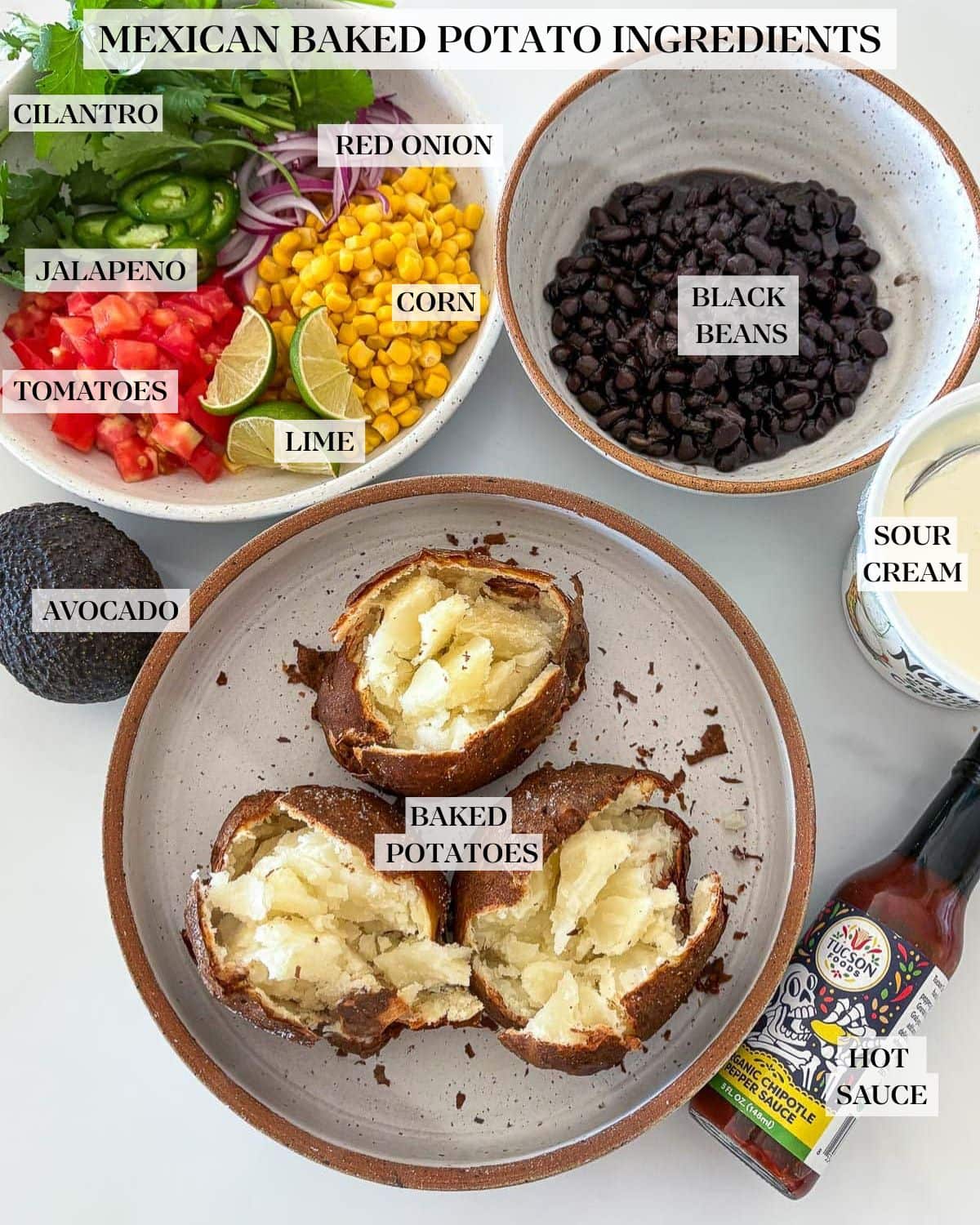 Ingredients in Mexican Baked potatoes on a white counter: baked russet potatoes, black beans, corn, tomatoes, jalapeno, cilantro and red onion.
